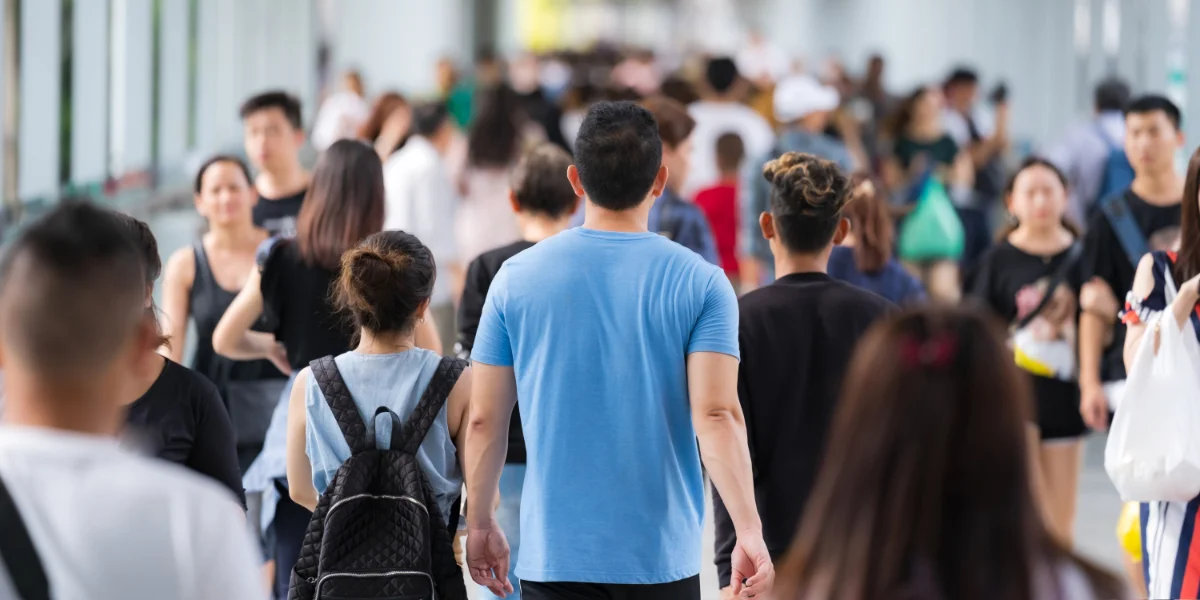 Crowd of anonymous people walking on a street